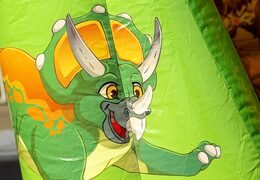 Small bouncer with roof to buy in green and orange color theme with dinosaur. Bouncers available at JB Inflatables America online