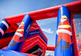 Inflatable covered bounce house in the theme of a fire department with a slide on the jumping surface, climbing tower and fun obstacles for kids. Buy bounce houses online at JB Inflatables America 