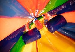 Order a circus crawl tunnel bouncer with obstacles, a climbing slope and a slide for kids. Buy bouncers online at JB Inflatables America 