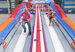 Opblaasbare Bungeerun springkussen bestellen voor kinderen in thema sterkste man. Attractie voor zeskamp sport en spel dorpsfeest bij JB Inflatables