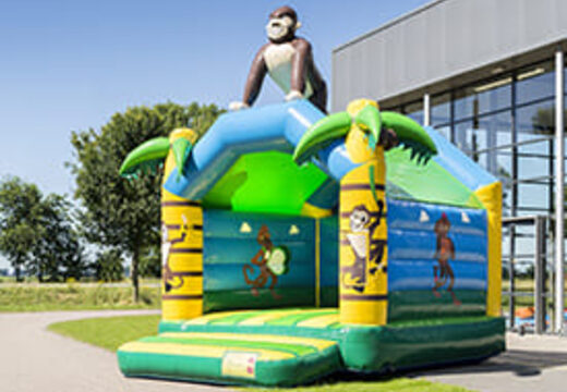 Buy a standard jungle bounce houses for children in striking colors with a large 3D object in the shape of a gorilla on the top. Order bounce houses online at JB Inflatables America